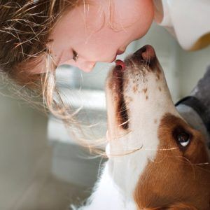 A girl and her dog bonding/kissing