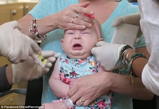 Mωρό μόλις 4 μηνών έχει πλαντάξει στο κλάμα, όταν η μαμά του, του τρυπάει τα αυτιά για να του βάλει σκουλαρίκια.