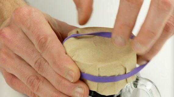 σφραγίζει το κοτσάνι του μανιταριού με ένα φίλτρο καφέ κι ένα λαστιχάκι έτσι ώστε να φυτέψει μανιτάρια