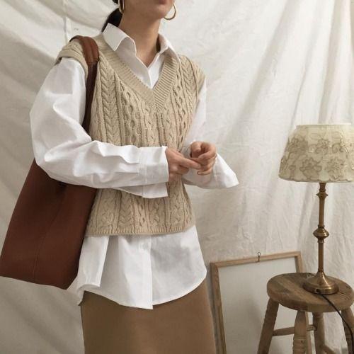 Knitwear outfit: Πλεκτή αμάνικη μπλούζα φορεμένη πάνω από λευκό πουκάμισο με καφέ φούστα και καφέ τσάντα 