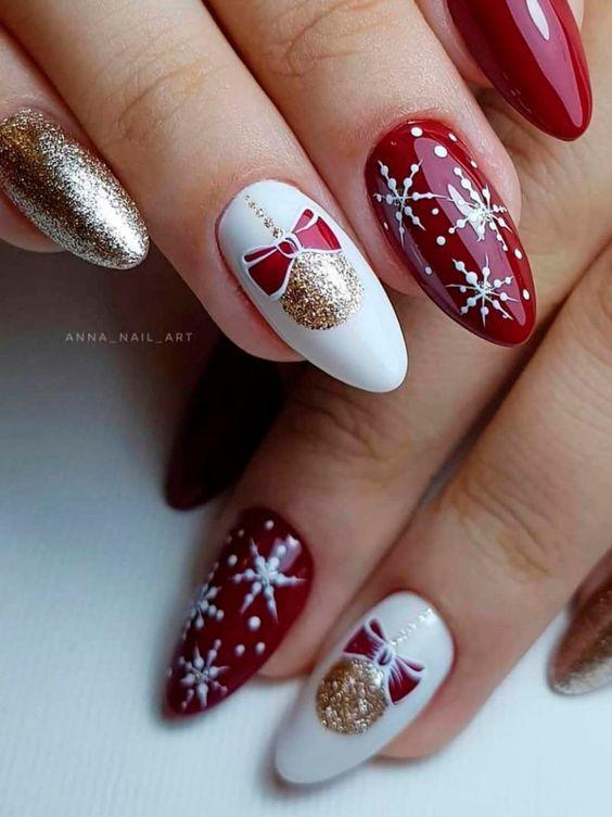 Κόκκινα και λευκά νύχια με ζωγραφισμένες χιονονιφάδες και χρυσά γκλίτερ για την Πρωτοχρονιά 