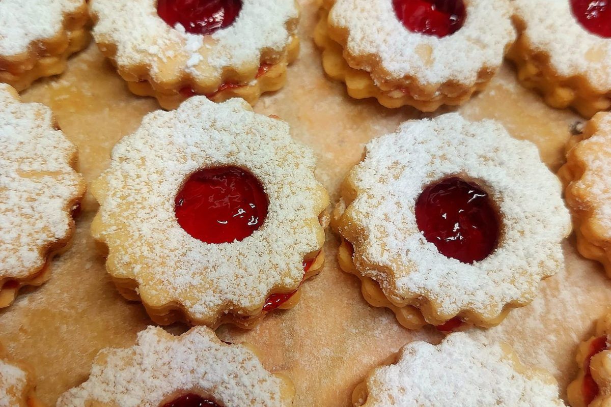 χριστουγεννιάτικα-μπισκότα αστεράκια-με-ζάχαρη άχνη-και-μαρμελάδα-σε-πιάτο-